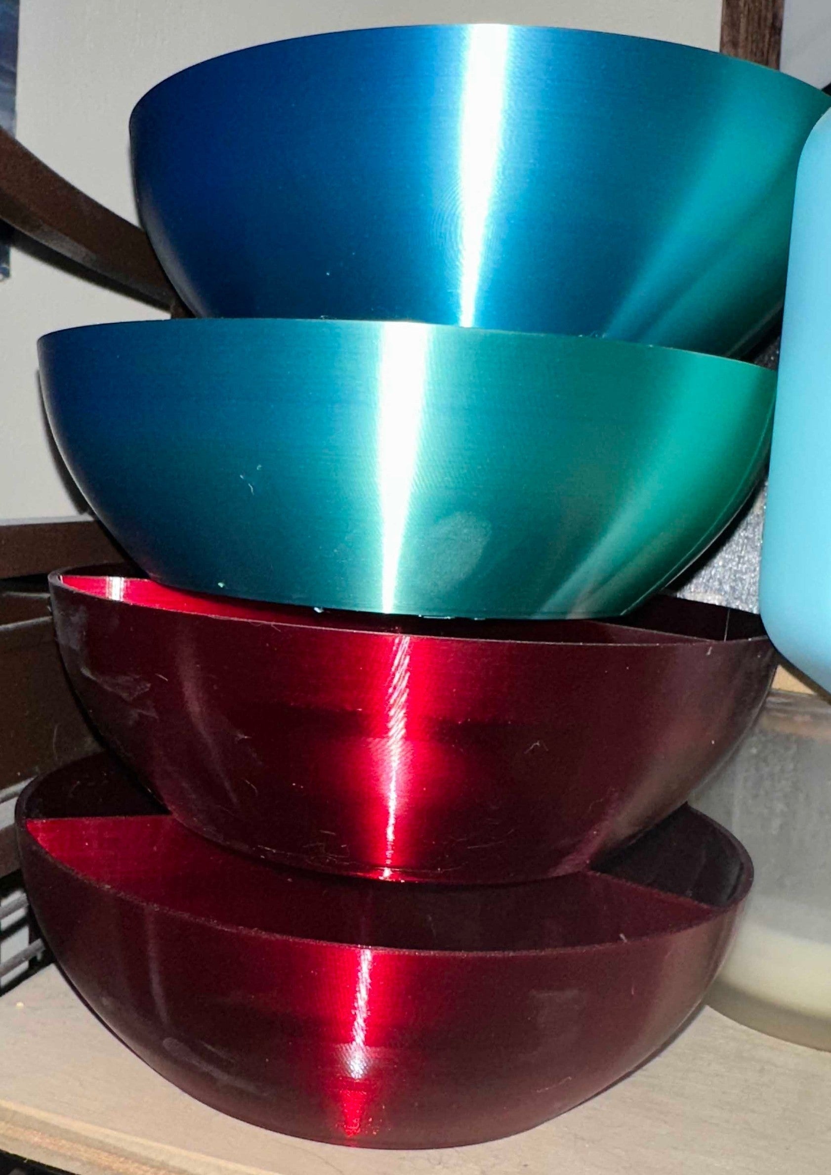 Papa Tee's set of four decorative serving bowls in metallic blue, teal, and red. Made of plastic with a high-gloss finish.
