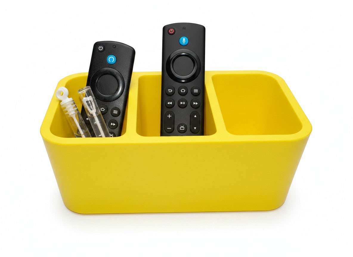 Papa Tee's vibrant yellow plastic remote control organizer caddy with three compartments holding two black remotes and two small bubble wands.