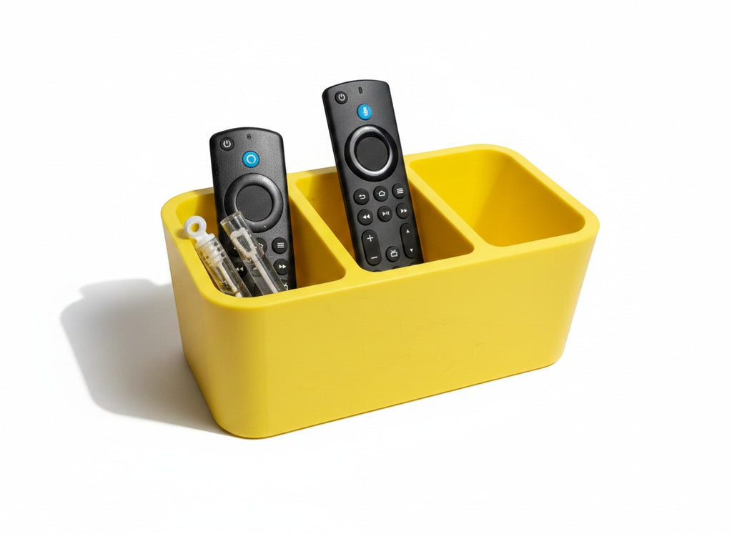 Papa Tee's vibrant yellow plastic remote control organizer with three compartments holding two remotes and small accessories.
