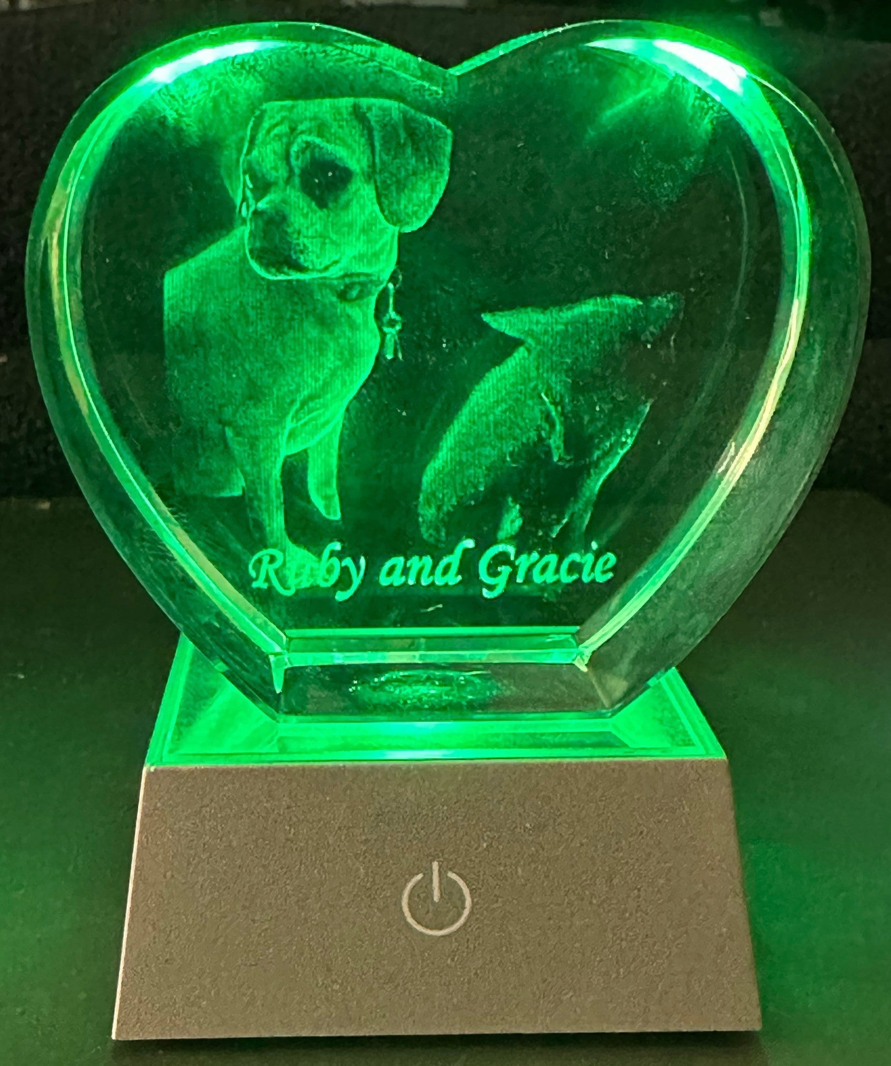 Papa Tee's heart-shaped crystal display with 3D engraved dogs, illuminated by a green LED base. Personalized keepsake.