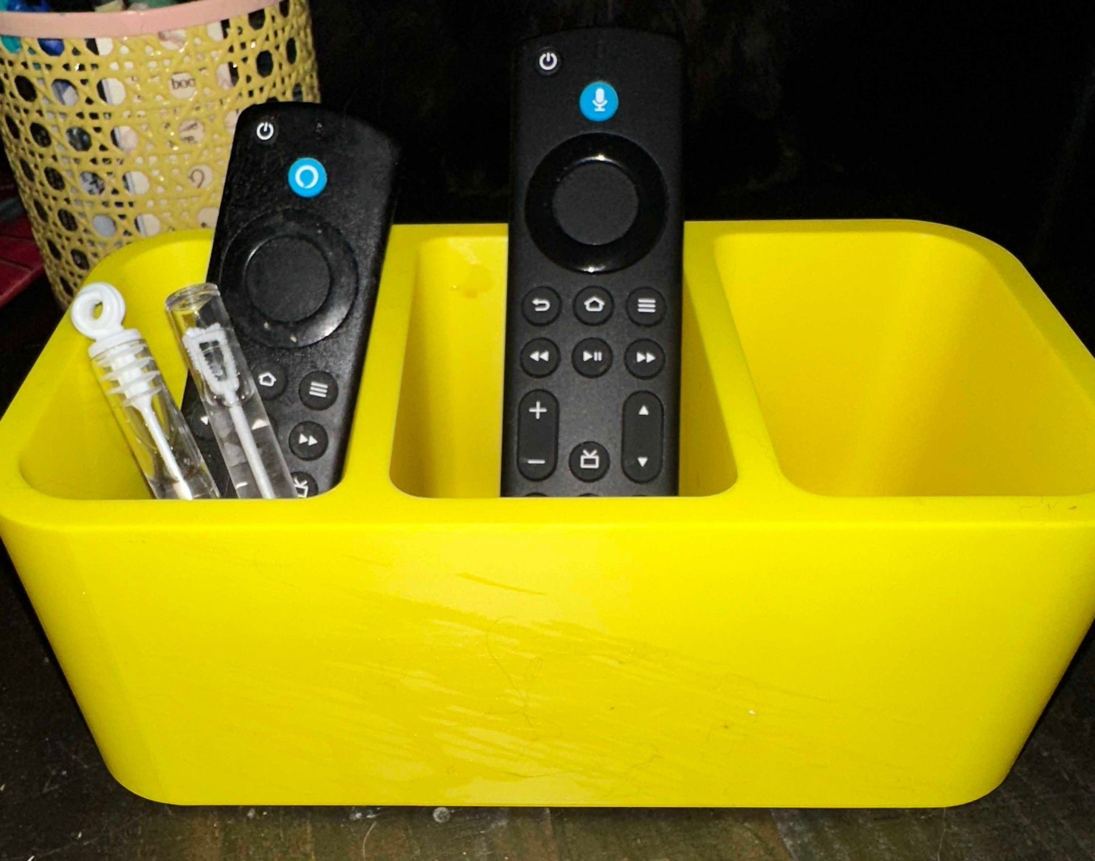 Papa Tee's vibrant yellow plastic remote control organizer with three compartments holding remotes and bubble wands.