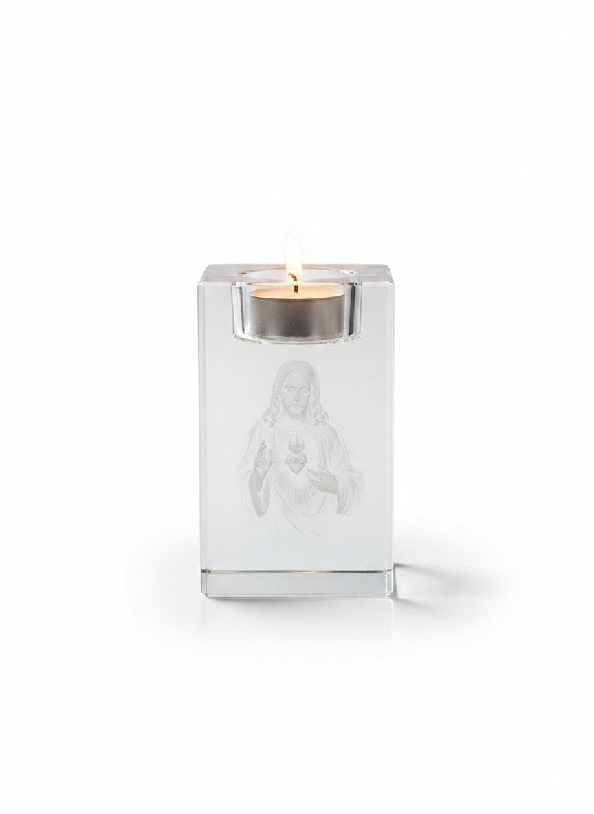 Papa Tee's clear crystal candle holder with 3D laser engraving of the Sacred Heart of Jesus, holding a lit tealight.