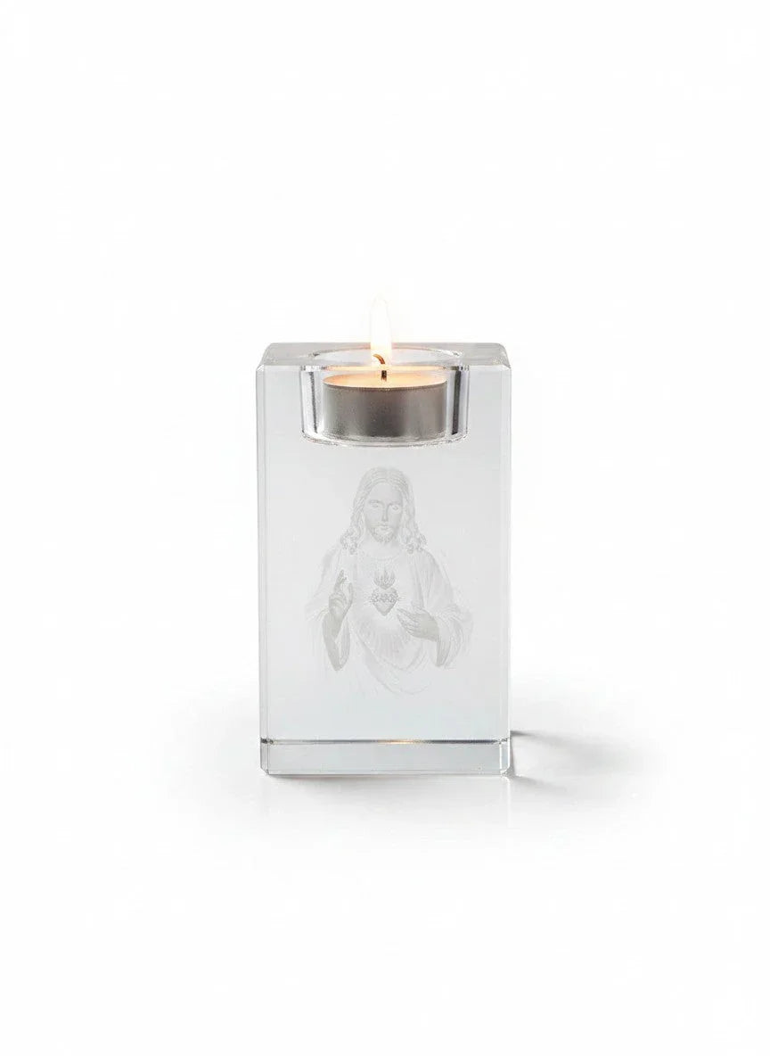 Papa Tee's clear crystal candle holder with 3D laser engraving of the Sacred Heart of Jesus, holding a lit tealight.