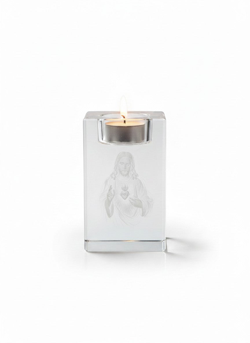 Papa Tee's clear crystal candle holder with 3D laser-engraved Sacred Heart of Jesus image, holding a lit tealight.